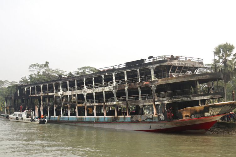 Sebuah kapal feri di Bangladesh terbakar terlihat berlabuh di lepas pantai distrik Jhalokati di Sungai Sugandha di Bangladesh, Jumat (24/12/2021). Sedikitnya 39 orang dilaporkan meninggal dalam tragedi tersebut. 