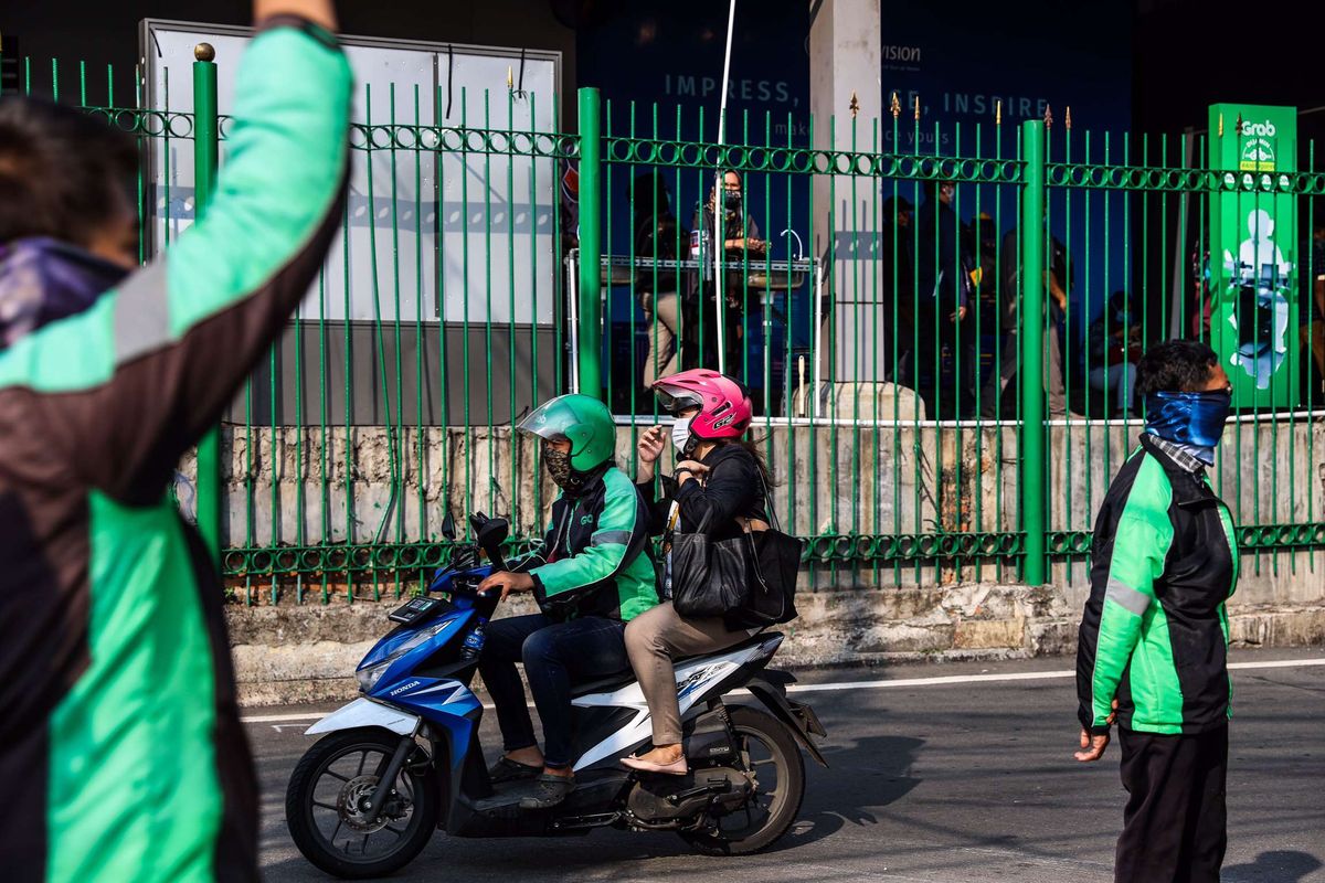 Pengemudi ojek online dengan penumpangnya melintas di Kawasan Stasiun Sudirman, Jakarta Pusat, Senin (8/6/2020). Pemerintah Provinsi DKI Jakarta mengizinkan pengemudi ojek online beroperasi untuk mengangkut penumpang selama PSBB transisi dengan menerapkan protokol kesehatan.