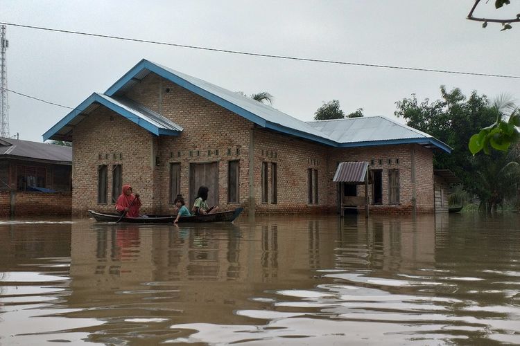 Warga beraktivitas di tengah banjir yang semakin tinggi menggunakan perahu di Desa Buluh Cina, Kecamatan Siak Hulu, Kabupaten Kampar, Riau, Jumat (27/12/2019) pagi.
