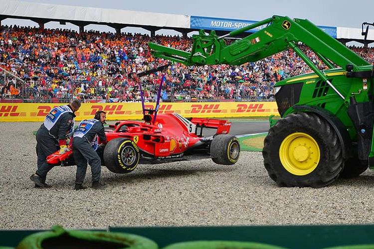 Traktor mengangkut mobil milik pebalap Ferrari Sebastian Vettel usai menabrak pembatas lintasan pada balapan Formula 1 (F1) GP Jerman yang berlangsung di Hockenheimring, Hockenheim, Jerman, Minggu (22/7/2018). Kemenangan diraih pebalap Mercedes Lewis Hamilton secara dramatis setelah mengawali balapan dari urutan ke-14.