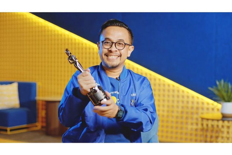 Chief People Officer tiket.com Dudi Arisandi memegang piala penghargaan Best Company to Work for in Asia oleh HR Asia