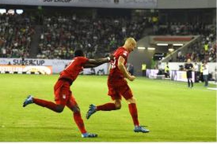 Gelandang Bayern Muenchen Arjen Robben (kanan) mendapat sambutan dari rekannya, David Alaba, setelah mencetak gol ke gawang Wolfsburg pada laga Piala Super Jerman di Wolfsburg, Sabtu (1/8/2015).