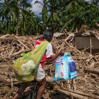 Warga melintasi jalan akses antardesa pascabanjir bandang di Desa Tanjung Karang, Karang Baru, Kabupaten Aceh Tamiang, Aceh, Minggu (7/12/2025). Akses penghubung Desa Tanjung Karang dan Desa Menang Gini yang sempat tertutup tumpukan kayu gelondongan akhirnya bisa terbuka usai pemerintah mengerahkan alat berat untuk pembersihan sehingga mobilitas masyarakat, termasuk distribusi bantuan menjadi bisa dilakukan. 