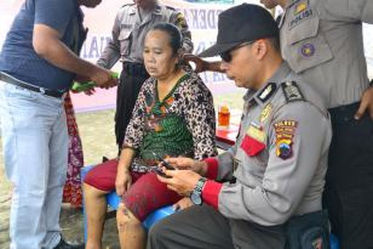 Tanisah bersama anggota Kepolisian Resort Kota Tegal, Jawa Tengah, setelah sadarkan diri karena tenggelam di Pantai Alam Indah. Rabu (12/2/2014)
