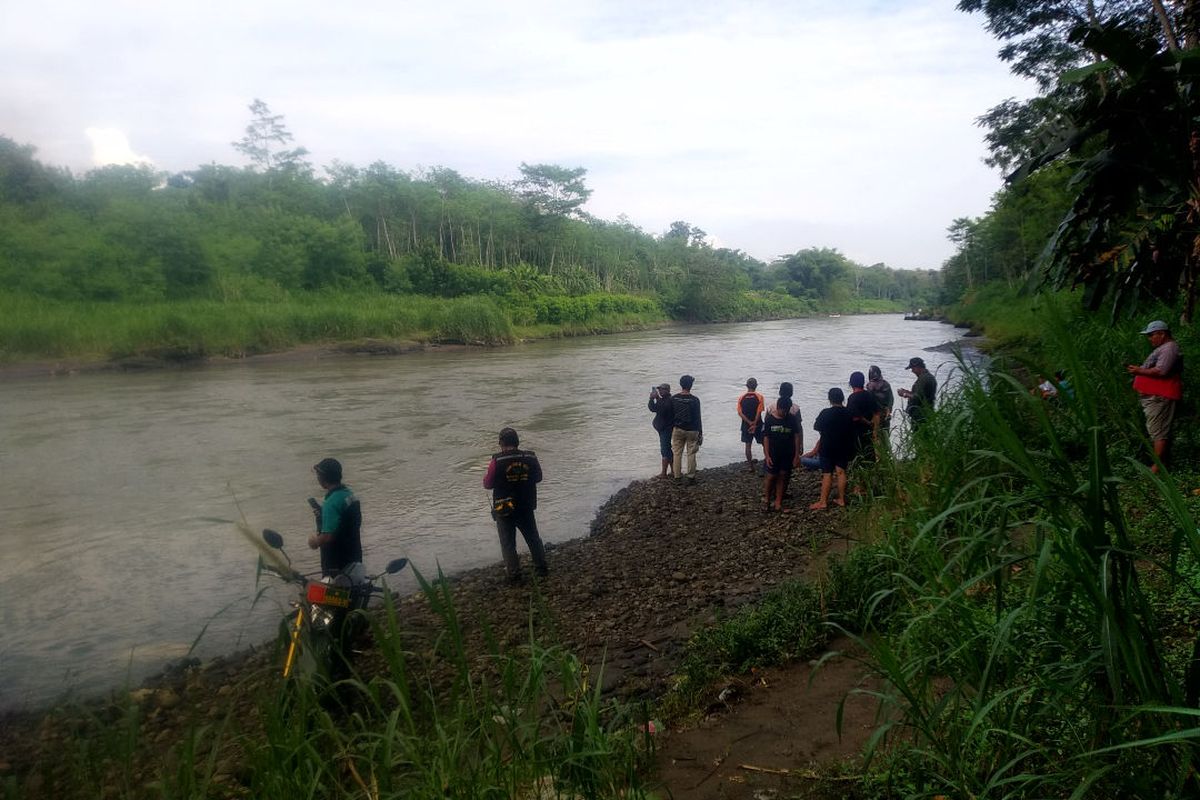 Sejumlah warga menyaksikan proses pencarian M Dava Nur Ilham (19) yang hanyut saat menyeberangi Sungai Brantas di Dusun, Gendong, Desa Purworejo, Kecamatan Sanankulon, Kabupaten Blitar, Rabu (28/5/2025)