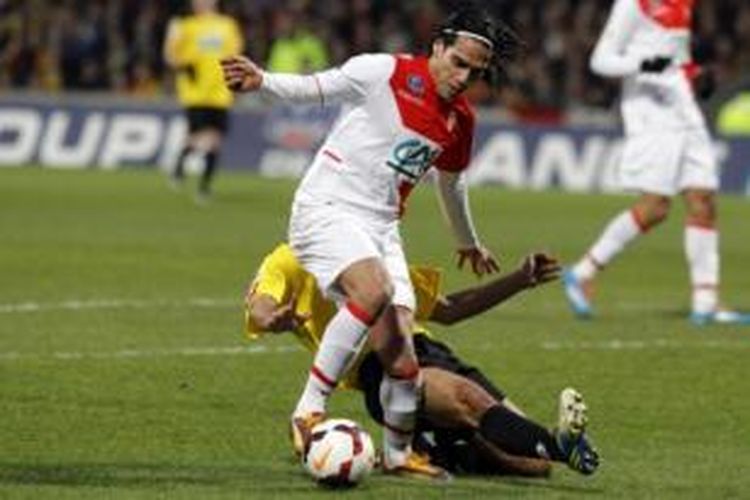 Striker AS Monaco, Radamel Falcao (kiri), ditekel oleh bek Chasselay, Soner Ertek (kuning), pada laga Coupe de France di Stade de Gerland, Lyon, Rabu (22/1/2014). Tekel tersebut membuat Falcao mengalami cedera lutut. 