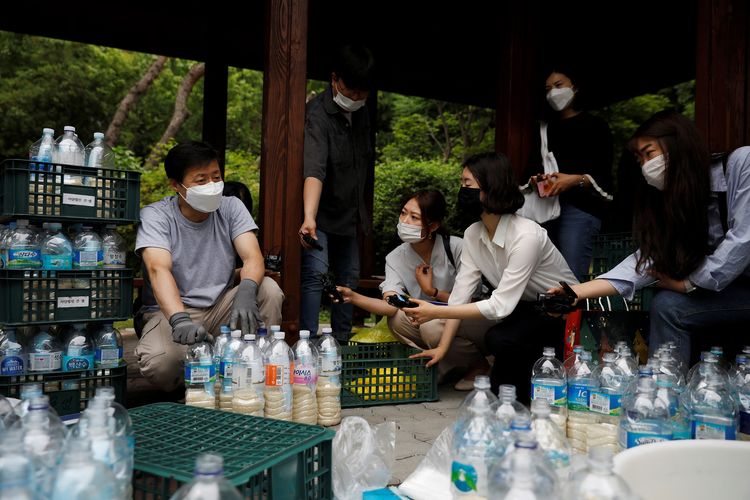 Ketua kelompok pembelot Korea Utara Kuensaem, Park Jung-oh (kiri), saat diwawancarai media ketika menyiapkan paket bantuan berupa botol plastik isi beras dan masker ke Korea Utara. Foto diambil di Seoul, Korea Selatan, pada 18 Juni 2020.