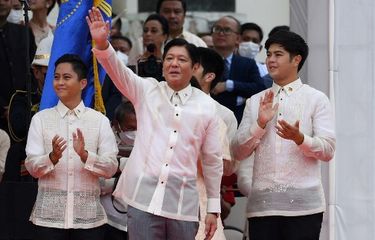 Presiden baru Filipina Ferdinand Marcos Jr (tengah) melambaikan tangan kepada para pendukungnya bersama putra-putranya, setelah dilantik sebagai pemimpin baru negara itu, dalam upacara peresmian di Museum Nasional di Manila pada 30 Juni 2022.