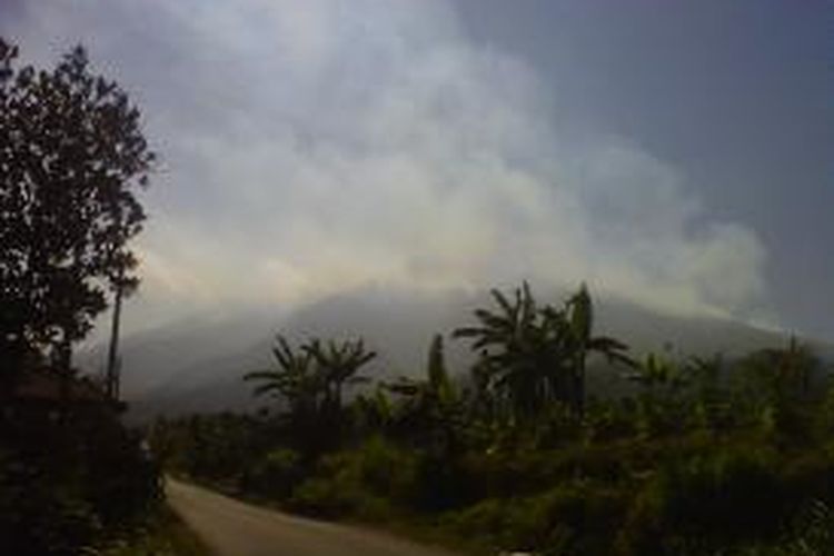 Puncak Gunung Merbabu terlihat tetutup asap akibat kebakaran, dilihat dari Desa Banyuroto, Kecamatan Sawangan, Kabupaten Magelang, Jumat (21/8/2015).