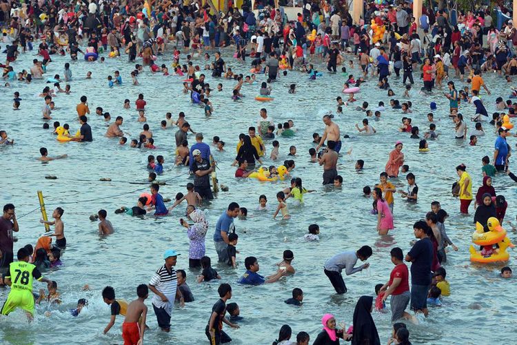 Pengunjung bermain air laut ketika mengunjungi kawasan Pantai Ancol, Jakarta, Rabu (27/6/2018). Ancol menjadi salah satu tujuan rekreasi warga untuk menghabiskan libur nasional dalam rangka pilkada serentak karena manajemen Ancol menggratiskan tiket bagi warga yang memiliki KTP DKI Jakarta.