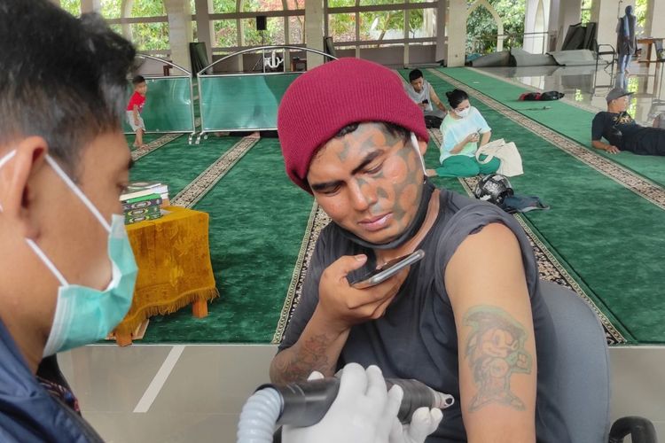 Ekspresi Bima Abdul Sholeh (35) saat tatonya sedang dihapus menggunakan laser di Masjid Darul Jannah yang terletak di Kantor Wali Kota Jakarta Selatan, Kamis (13/4/2023) 