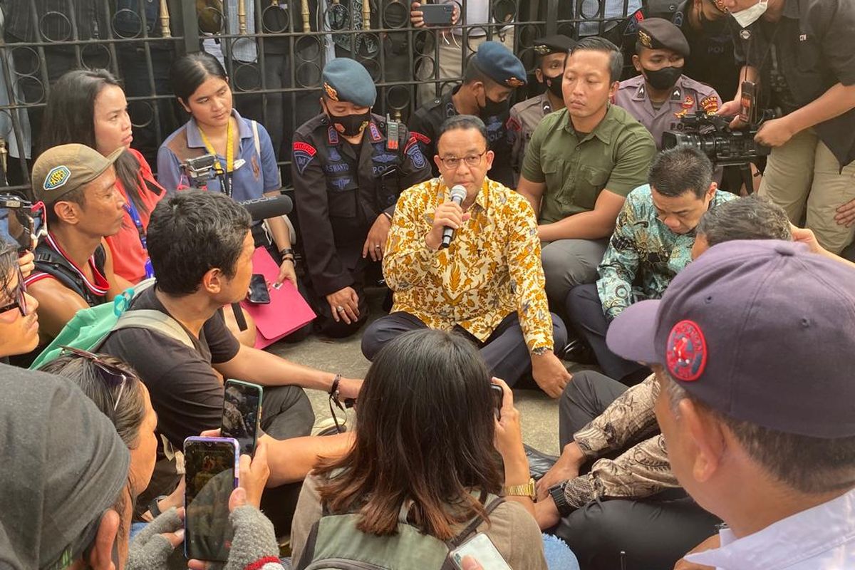 Gubernur DKI Jakarta Anies Baswedan menemui massa aksi di depan Balai Kota DKI Jakarta, Jumat (14/10/2022). Sambil lesehan, dia mendengarkan dan merespons tuntutan yang dilayangkan massa Koalisi Perjuangan Warga Jakarta (KOPAJA). 
