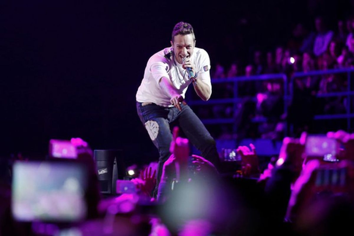Vokalis Coldplay, Chris Martin menyapa penonton saat konser. 