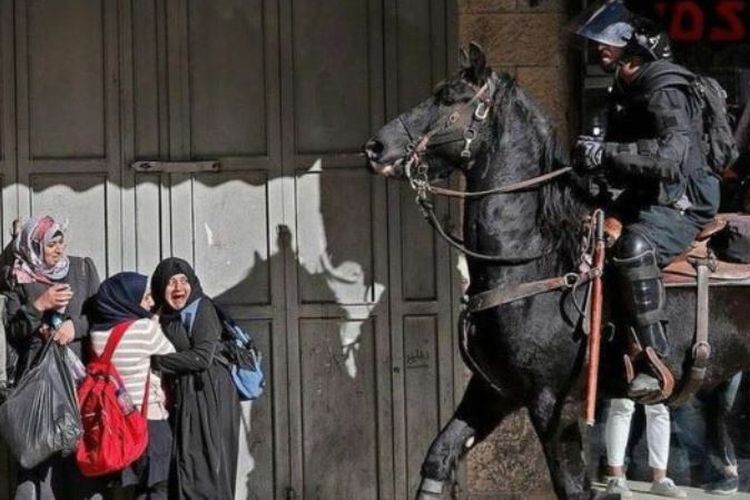 Seorang polisi Israel yang menunggang kuda membuat sejumlah perempuan Palestina ketakutan.