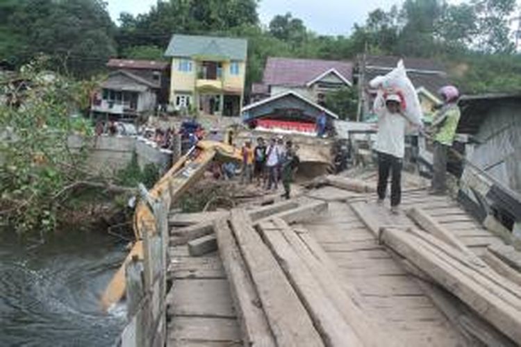 Jembatan Benanga sebagai satu-satunya akses jembatan dari kayu di Desa Muang Dalam, Kecamatan Samarinda Utara, Kalimantan Timur, ambruk akibat dilintasi eskavator atau alat berat, Senin (9/6/2014). 