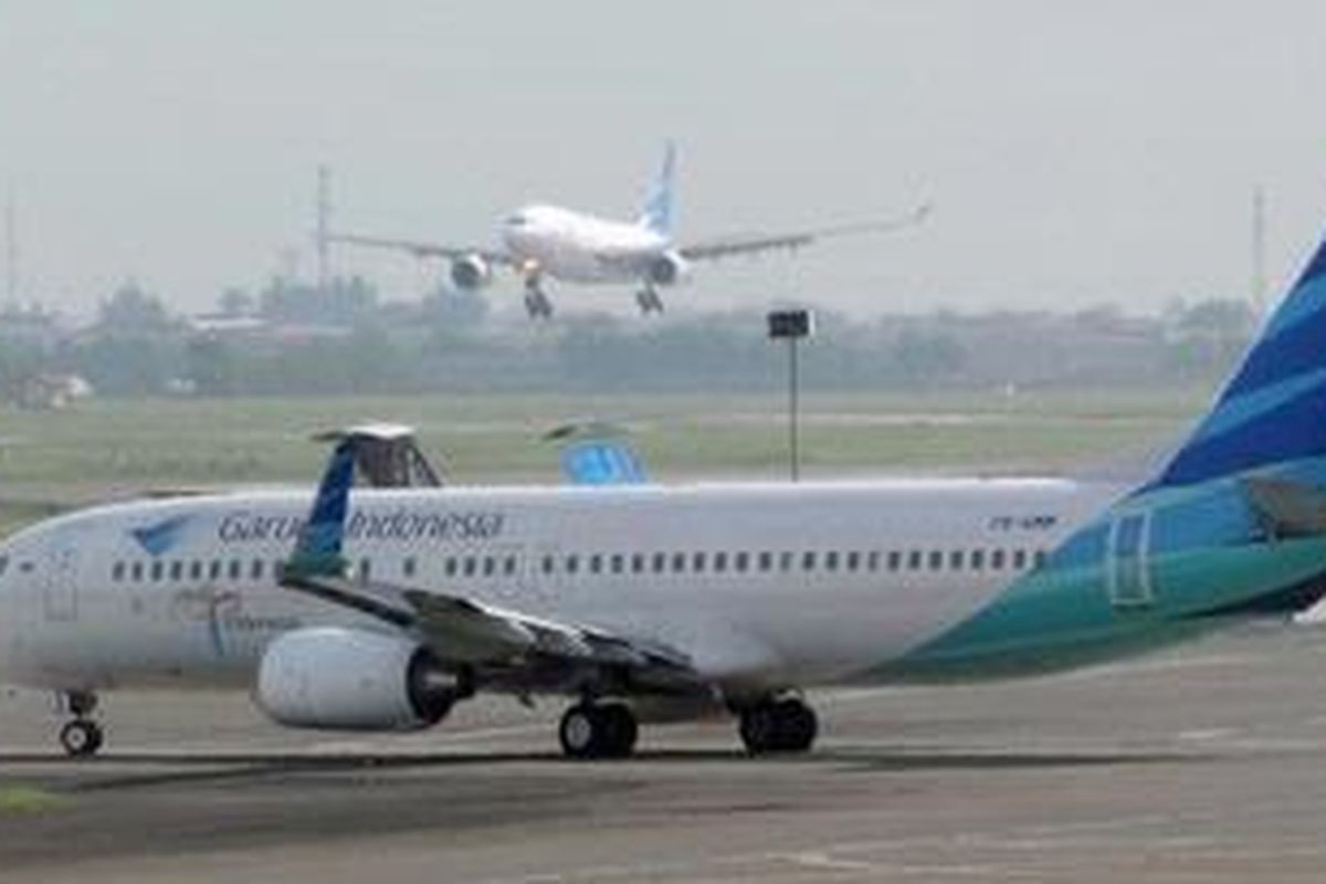 This photograph taken on October 26, 2010, an Indonesian Garuda Airline plane lands and another prepares to take off at Soekarno-Hatta airport in Jakarta.