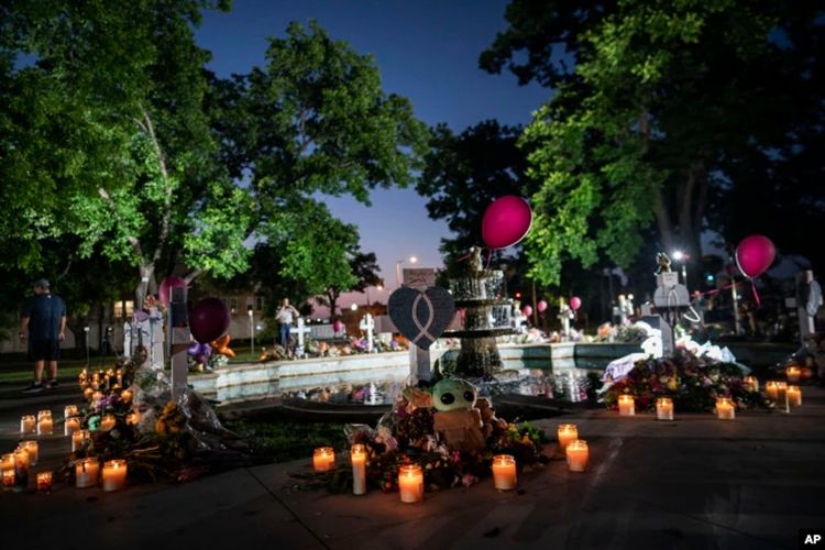 Penyalaan lilin di alun-alun kota untuk mengenang para korban yang tewas dalam penembakan sekolah dasar minggu ini di Uvalde, Texas.