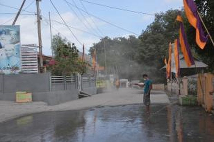 Masyarakat di Kota Ternate berusaha menyiram abu vulkanik di jalan-jalan pasca-meletusnya Gunung Gamalama, Kamis (16/7/2015).