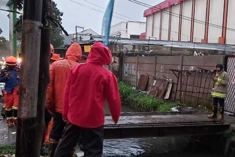 Petugas tengah melakukan pencarian seorang anak yang terseret arus dan tenggelam di parit di Bandung.