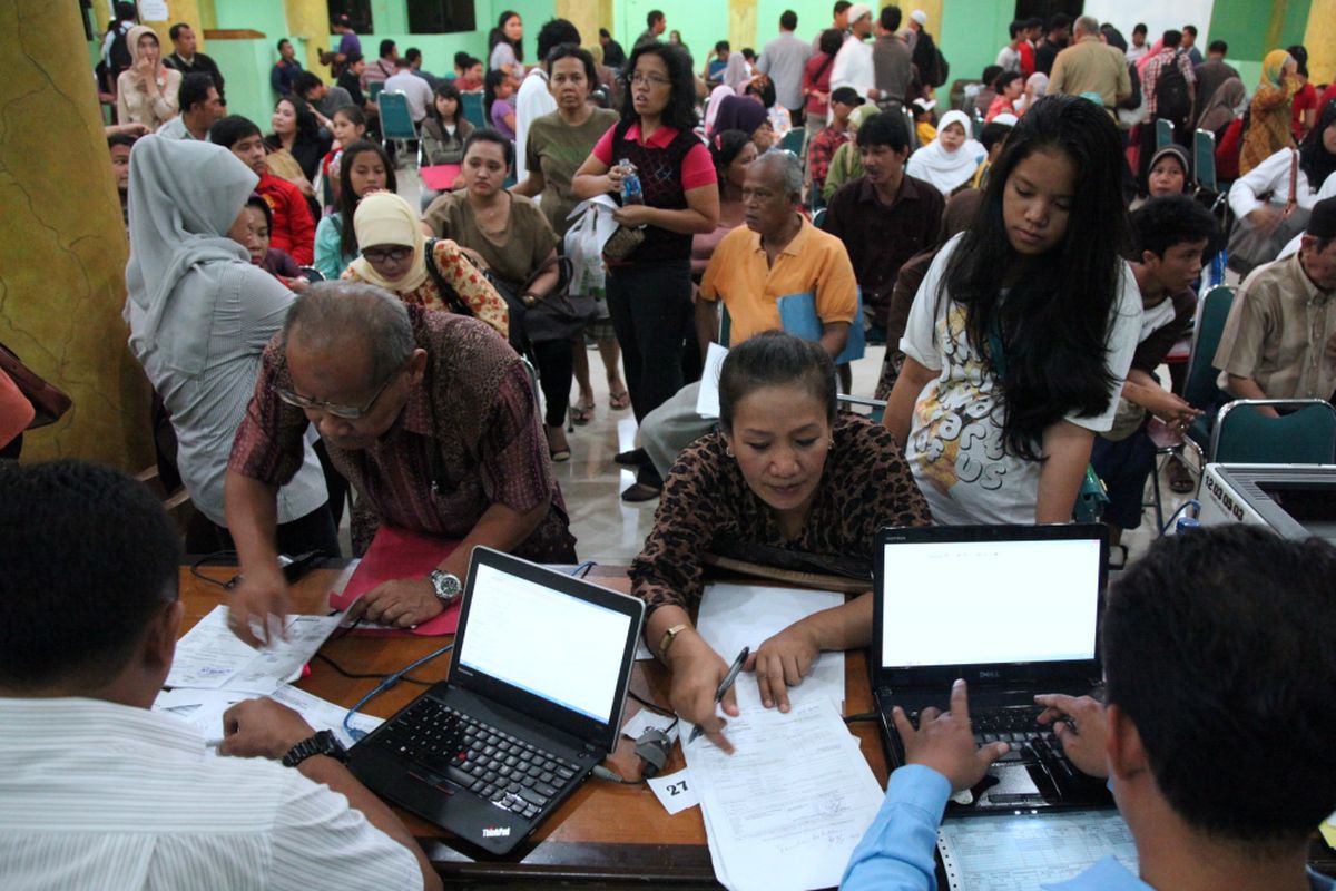 Warga dilayani petugas di posko penerimaan peserta didik baru di Dinas Pendidikan DKI Jakarta, Selasa (2/7/13). Menurut sejumlah petugas, sebagian warga meminta
perubahan data alamat domisili sesuai kartu keluarga yang baru. Perubahan dilakukan agar anak mereka bisa mendaftar di sekolah yang dituju. 