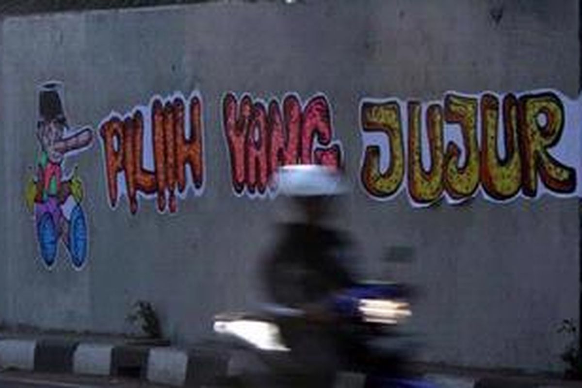 Pengendara melintas di depan sebuah lukisan tembok kota (mural) yang mengingatkan untuk memilih pemimpin yang jujur di Jalan Sultan Agung Jakarta Selatan, Minggu (1/7/2012).  