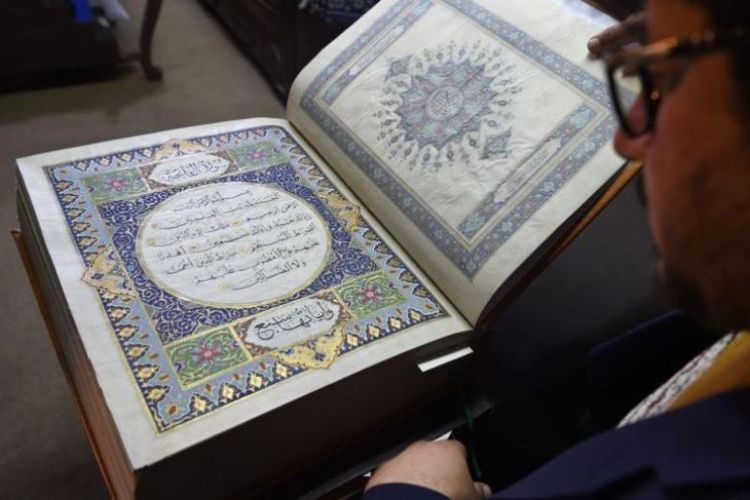 Seniman Afganistan Mohammad Tamim Sahibzada menunjukkan Al Quran buatan tangan yang dibuat dari kain sutra di Turquoise Mountain Foundation, Mourad Khani, di bagian kota tua Kabul, Afghanistan. (AFP/Wakil Kohsar)