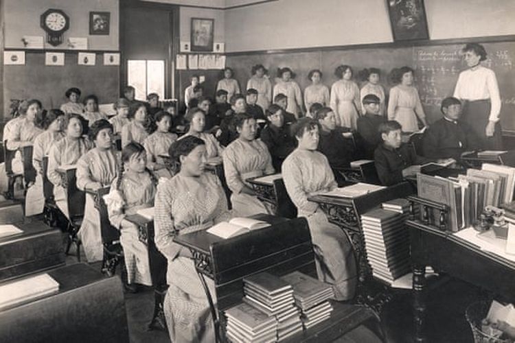 Para siswa pribumi Amerika di sebuah kelas di Genoa US Indian Industrial School di Nebraska pada 1910. [National Archives and Records Administration Via The Guardian]