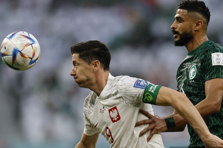 Penyerang Polandia, Robert Lewandowski, berebut bola dengan bek Arab Saudi, Abdulelah Alamri, dalam laga Grup C Piala Dunia 2022 Polandia vs Arab Saudi di Education City Stadium, Al-Rayyan, Doha. 26 November 2022.