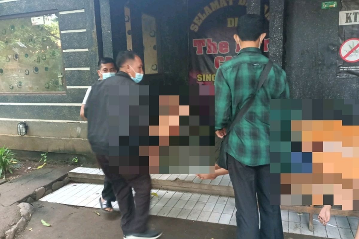 Polisi saat mengevakuasi tiga wanita yang mengaku disekap di sebuah kafe di Buleleng Bali. 