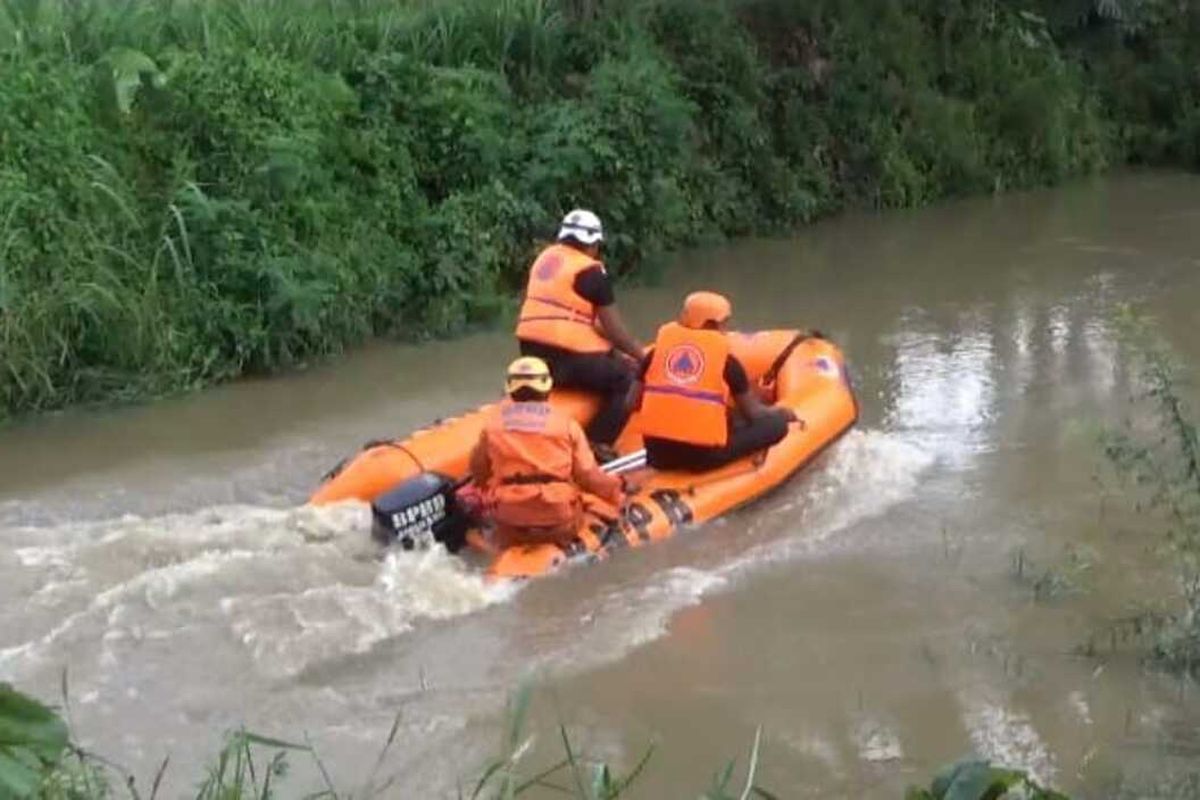 Petugas gabungan dari Basarnas dan BPBD Jombang melakukan pencarian terhadap pedagang bawang merah, yang diperkirakan tergelincir dan hanyut di aliran sungai Avour Besuk, Kabupaten Jombang, Jawa Timur, Senin (7/2/2022).