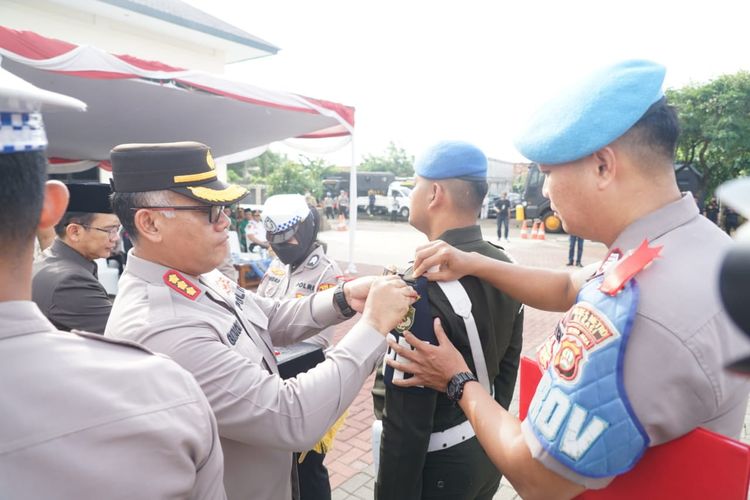 Kapolres Metro Bekasi Kombes Pol Gidion Arif Setyawan (kiri) saat menyematkan pita merah sebagai tanda dimulainya Operasi Lilin Jaya 2022, Kamis (22/12/2022).