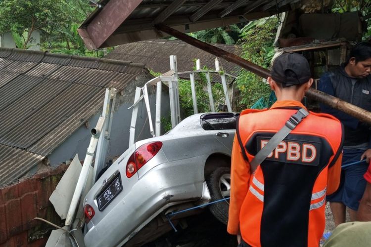 Petugas BPBD sedang mengevakuasi satu unit mobil warga yang tergerus material longsor di kawasan Puncak Bogor atau tepatnya Kampung Cidokom, Desa Kopo, Kecamatan Cisarua, Kabupaten Bogor, Jawa Barat, Jumat (30/12/2022).