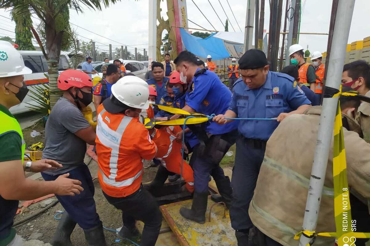 Sejumlah petugas Pemadam Kebakaran Deli Serdang dan PGN mengevakuasi dua orang petugas PGN yang terjebak tewas di gorong-gorong di Tanjung Morawa, Deli Serdang pada Jumat (27/5/2022) siang.
