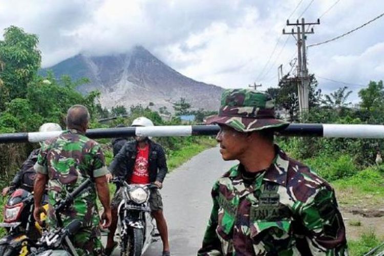 Petugas memperingatkan dua warga yang hendak keluar dari zona merah erupsi Sinabung di portal simpang Sibintun, Kecamatan Simpang Empat, Kabupaten Karo, Rabu (2/11/2016). Meskipun status Gunung Sinabung Awas dan potensi erupsi dan luncuran awan panas tinggi, peringatan untuk tidak beraktivitas di zona merah Sinabung masih terus dilanggar warga.