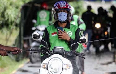 Petugas menyemprot disinfektan kepada pengendara ojek online setelah pembagian masker di Jl. Letjen S. Parman, Jakarta Barat, Senin (4/5/2020). Provinsi DKI Jakarta memasuki pelaksanaan pembatasan sosial berskala besar (PSBB) yang diperpanjang ke tahap kedua. Tujuan PSBB ini adalah untuk menekan penyebaran virus corona (Covid-19).