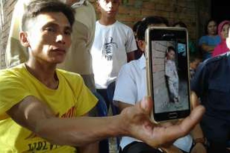 Salbani (30) memperlihatkan foto almarhum sang anak tadi sore di kediamannnya