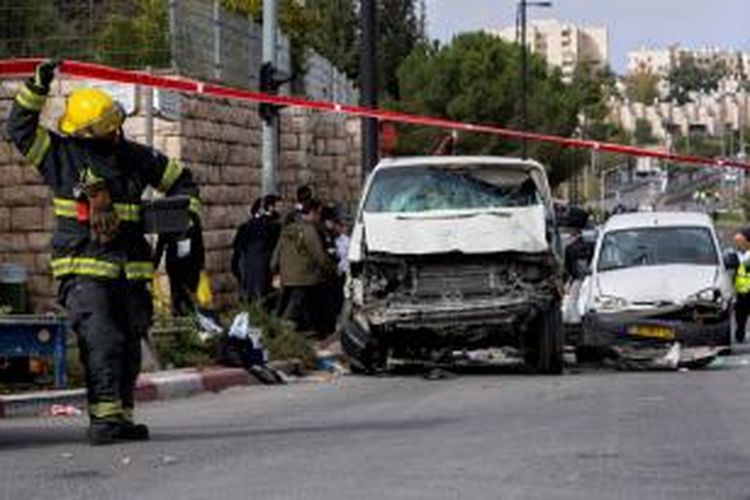 Seorang petugas melintas di depan sebuah mobil yang digunakan seorang pria Palestina menabrak para pejalan kaki di Jerusalem, Rabu (5/11/2014).