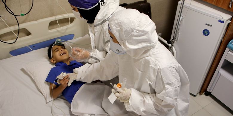 Perawat mengambil sampel swab dari Parham, bocah berusia tujuh tahun untuk tes wabah Covid-19 di rumah sakit Teheran, Iran, pada 8 Juli 2020.