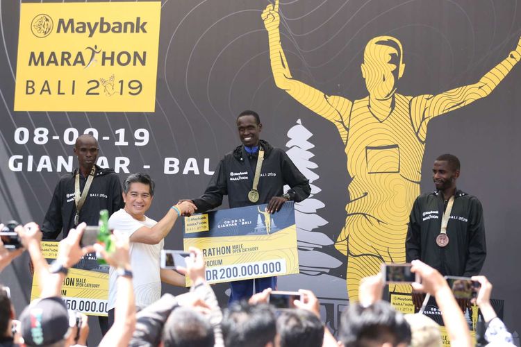 Tazwin Zakaria Presiden Direktur Maybank Indonesia memberikan hadiah kepada Pelari Kenya Kirui Simon Kiprugut yang menjadi juara I kategori marathon open di lomba lari Maybank Marathon Bali 2019, di Gianyar, Bali, Minggu (8/9/2019), dengan catatan waktu 2 jam 18 menit 34 detik.