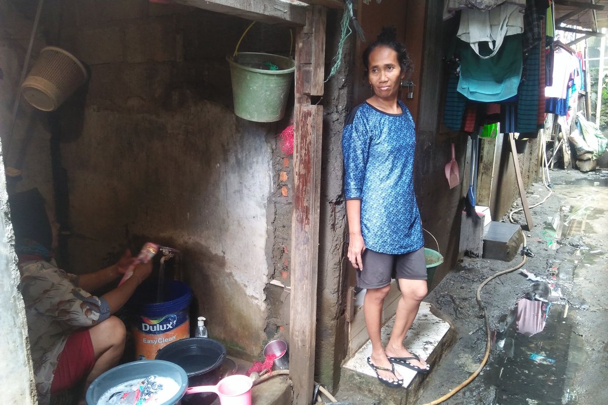 Rohimah, warga Pegangsaan Dua yang sedang mencuci pakaian sisa banjir bersama tetangganya, Siti, Kamis (27/2/2020).