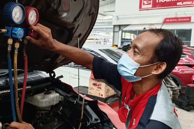 Mekanik bengkel resmi Astra Daihatsu Majapahit Semarang sedang melakukan perbaikan AC mobil. 