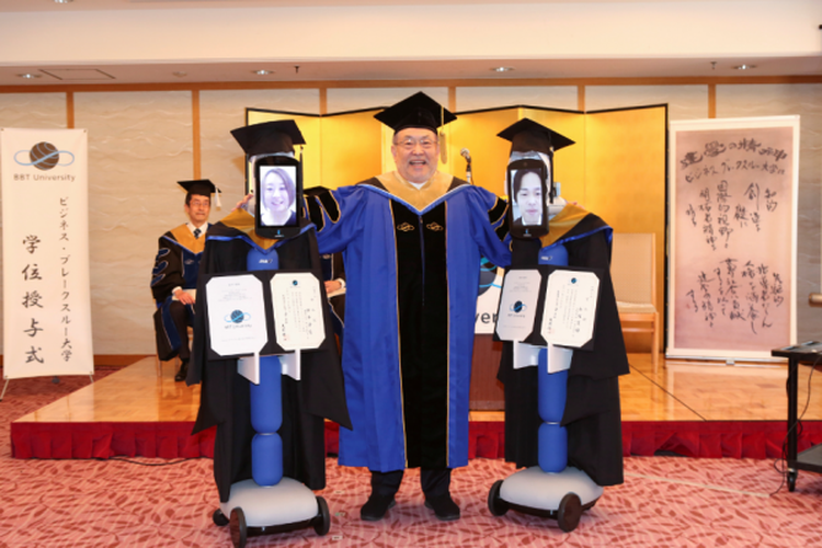 Pihhak BBT University berfoto bersama dengan dua robot Newme yang menampilkan wajah wisudawan.