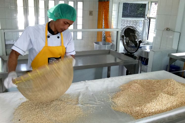 Pngerajin tempe sedang melakukan tahapan penyaringan tunas, setelah kedelai diberi ragi di Rumah Tempe Indonesia (RTI), Bogor, Selasa (23/5/2017).