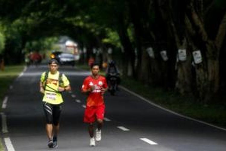 Sitor Torsina Situmorang (kiri) peserta lomba lari Trans Sumbawa dalam rangkaian Tambora Challenge 2015 lintasi Jalan Trans Sumbawa di Kecamatan Alas, Sumbawa, NTB, Rabu (8/4/2015). Lomba lari yang diikuti 8 peserta dengan 25 pelari pendamping ini dilepas dari Poto Tano dan finis di Doro Ncanga yang berjarak sekitar 320 kilometer.