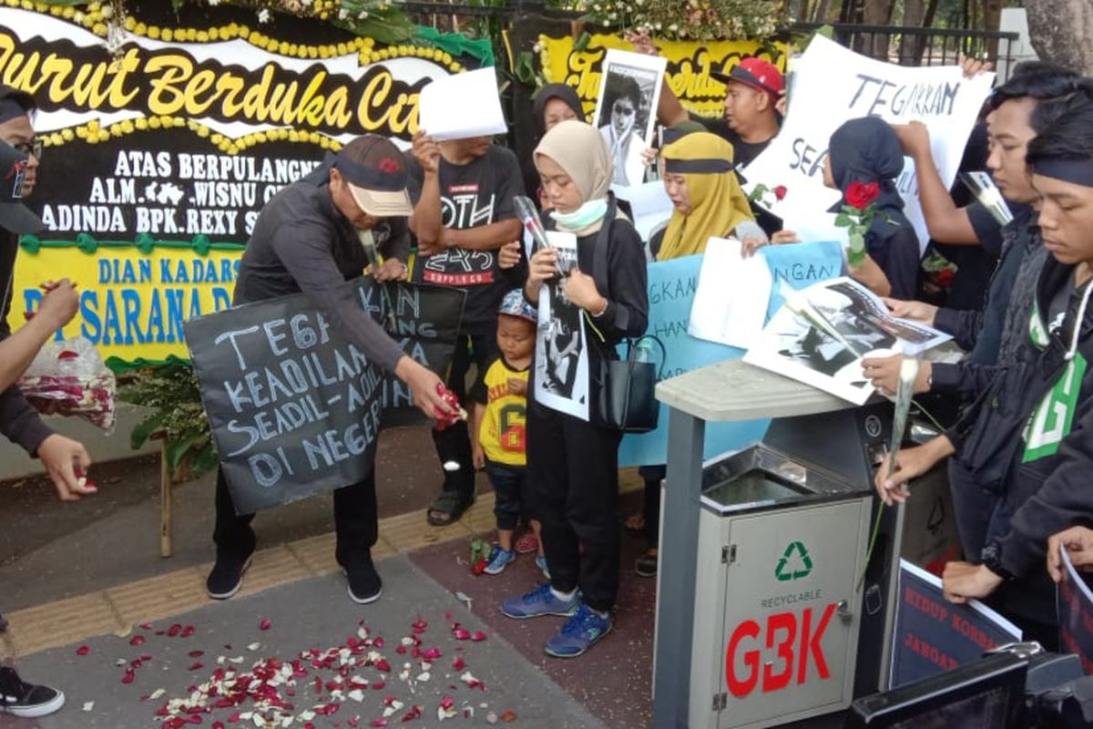 Keluarga dan kerabat pengguna skuter listrik GrabWheels yang tewas ditabrak, Wisnu (18) dan Ammar (18), menggelar aksi tabur bunga di Pintu 3 Gelora Bung Karno, Senayan, Jakarta, Minggu (17/11/2019).