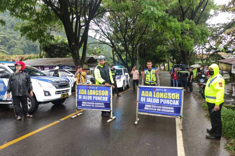 Petugas gabungan kepolisian melakukan pengalihan arus lalu lintas kendaraan roda dua dan empat yang menuju ke wilayah Cianjur Kota dan Bandung di Jalan Raya Cugenang, Cianjur, Jawa Barat, Rabu (23/11/2022).