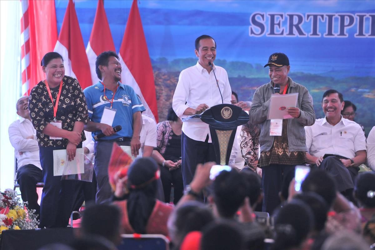 Presiden Joko Widodo saat membagikan sertifikat tanah kepada masyarakat di Kabupaten Samosir, Selasa (30/7/2019).