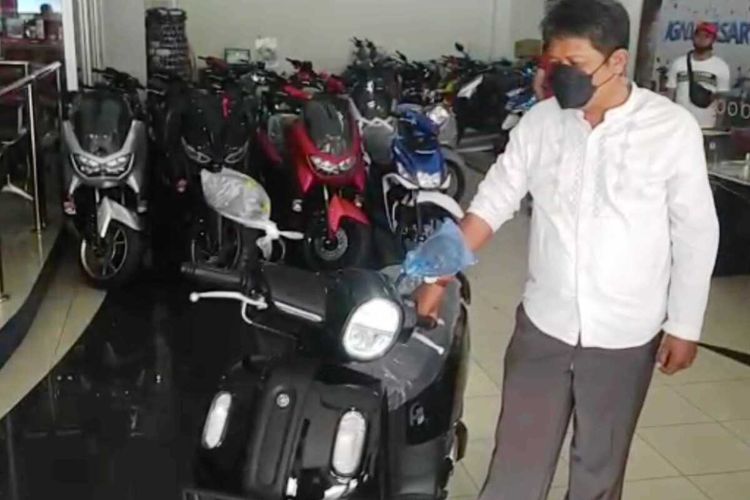 Aiptu Siswanto, anggota polisi di Cianjur, Jawa Barat, bersama sepeda motor yang baru dibelinya seharga Rp 22,1 juta menggunakan uang koin pecahan Rp 1.000