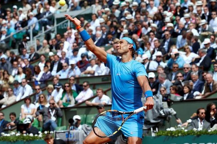 Petenis Spanyol, Rafael Nadal, melakukan servis saat bertemu Nicolas Almagro pada babak kedua Roland Garros di Paris, Kamis (28/5/2015). Nadal menang 6-4, 6-3, 6-1.