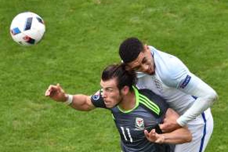 Bek Inggris, Chris Smalling (kanan), berduel dengan penyerang Wales, Gareth Bale, pada pertandingan penyisihan Grup B Piala Eropa 2016 di Stadion Bollaert-Delelis, Lens, Kamis (16/6/2016). Inggris menang 2-1.